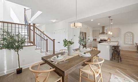 At the bottom of a levelled staircase, there is an open-concept dining area adjacent to a kitchen.